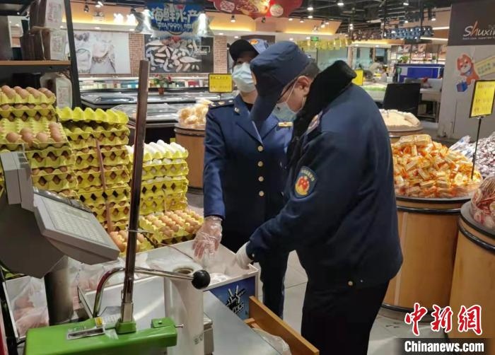 圖為疫情期間，甘肅嘉峪關(guān)市場監(jiān)管局工作人員檢查蔬菜市場?！?柴佳楠 　攝