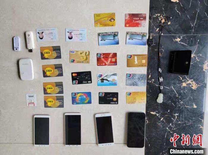 資料圖為果洛藏族自治州公安民警查扣的作案手機(jī)和涉案銀行卡。　瑪沁縣公安局供圖