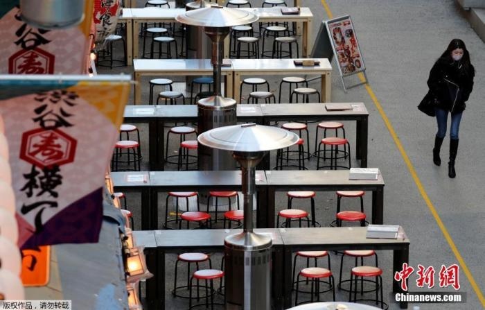 資料圖：日本東京，一名路人路過(guò)空蕩的戶外餐館。