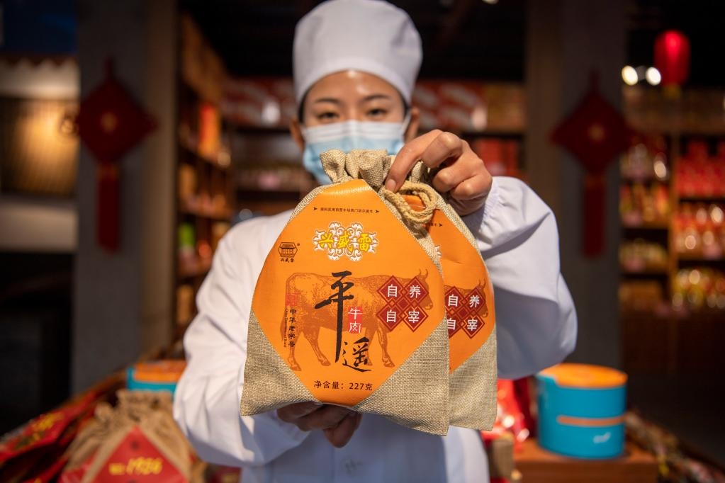 1月27日，在平遙古城南大街的一家平遙牛肉店內(nèi)，工作人員展示一款牛肉產(chǎn)品。新華社記者 楊晨光 攝