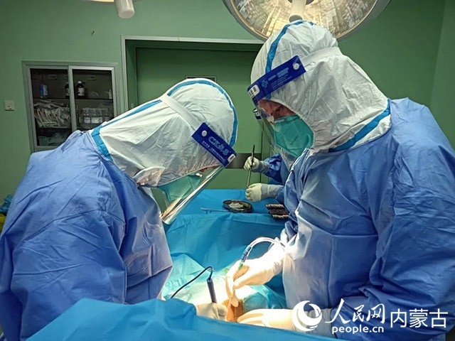 醫(yī)護(hù)人員正在為新冠肺炎合并腸梗阻腸穿孔的尿毒癥患者實施急診手術(shù)。呼和浩特市第一醫(yī)院供圖