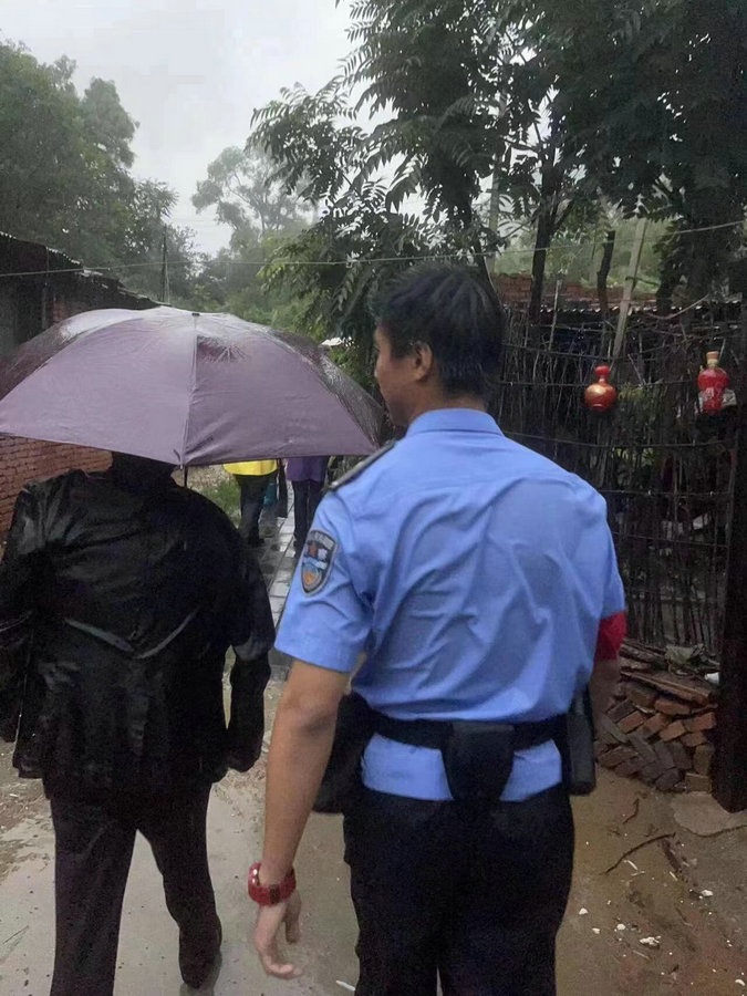 孫愉力誠(chéng)在雨中護(hù)送旅客轉(zhuǎn)移至安全地帶_proc.jpg