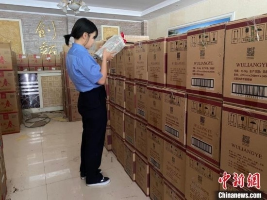 資料圖為檢察人員核對查獲的假冒品牌白酒。青海省人民檢察院供圖
