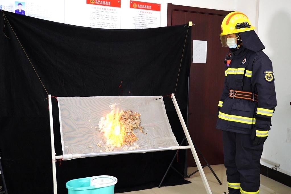 消防員在展示柳絮點燃實驗。 張少欣 攝