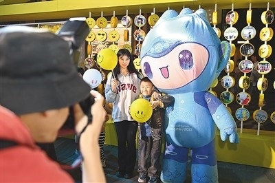 5月7日，在浙江省杭州市湖濱步行街“3D笑臉墻”前，攝影師為游客與杭州亞運會吉祥物之一“宸宸”拍攝合影。