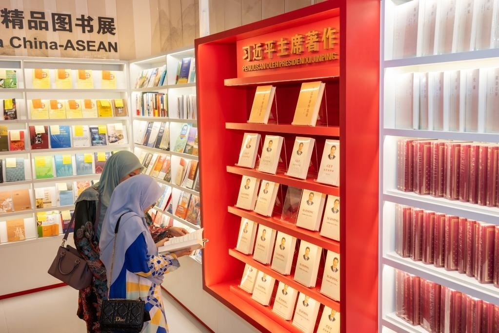 5月30日，兩名讀者在馬來西亞吉隆坡國際書展中國主賓國活動現(xiàn)場閱讀習(xí)近平主席著作。新華社記者朱煒攝