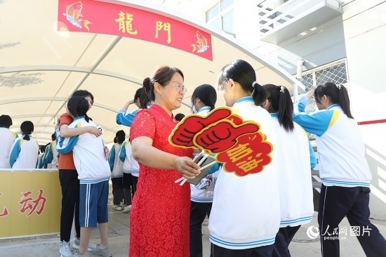 6月7日一早，雄安新區(qū)安新中學(xué)老師在給同學(xué)們加油鼓勁兒。人民網(wǎng) 李兆民攝