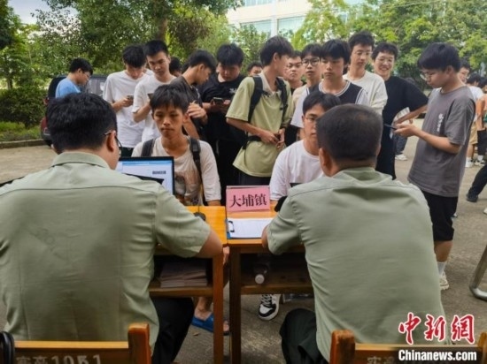 專武干部在發(fā)放兵役登記證。韋碩 攝