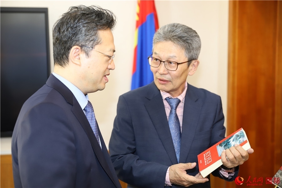 其米德策耶（右一）向李峙介紹翻譯成果。人民網(wǎng)記者 霍文攝