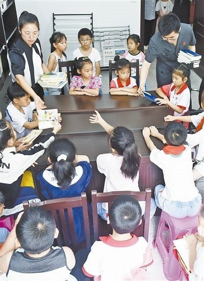  圖④：法院干警為留守兒童發(fā)放暑假讀物。