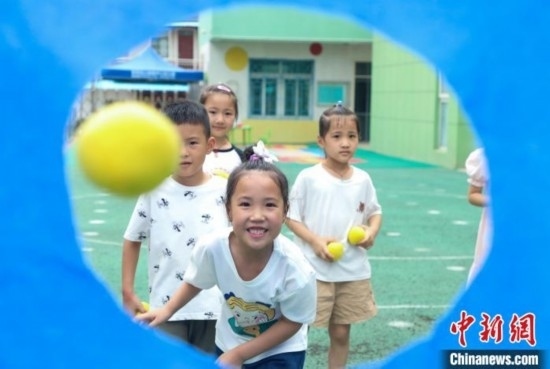 在肥西縣山南鎮(zhèn)中心幼兒園，孩子們在玩布洞投球游戲。陳家樂 攝