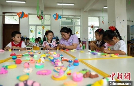 在肥西縣山南鎮(zhèn)中心幼兒園，孩子們在老師的指導(dǎo)下做彩色泥塑。陳家樂 攝