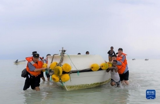 7月21日，中國海軍“和平方舟”號醫(yī)院船醫(yī)護人員涉水登島，前往基里巴斯一診療點。新華社記者 黎云 攝