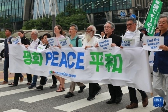 7月22日，在韓國首爾，人們手舉標語參與反戰(zhàn)游行。新華社發(fā)（楊暢 攝）