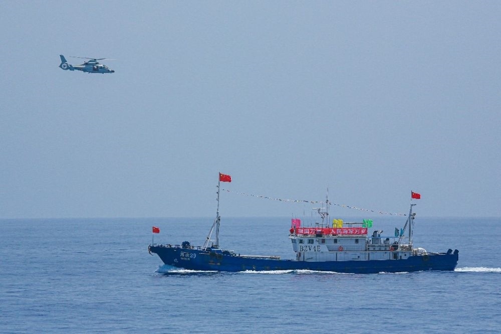 ↑中國海軍第40批護航編隊中的艦載直升機在被護船只周邊海域巡邏警戒（2022年6月4日攝）。新華社發(fā)（唐文 攝）
