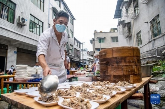 7月29日，在重慶市綦江區(qū)安穩(wěn)鎮(zhèn)，當?shù)鼐用裨凇懊缂曳蚬?jié)”上準備羊肉長桌宴。新華社記者 唐奕 攝