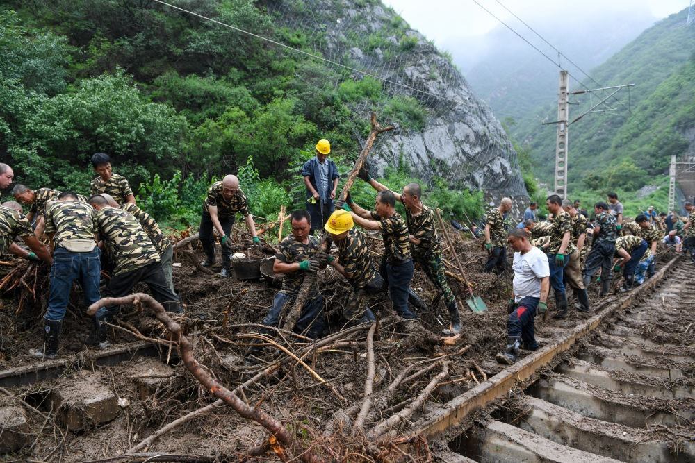 8月1日，在北京市門頭溝區(qū)水峪嘴村附近一段被阻斷的鐵路線上，中鐵六局工作人員在清理軌道上的雜物，全力恢復(fù)交通。新華社記者 鞠煥宗 攝