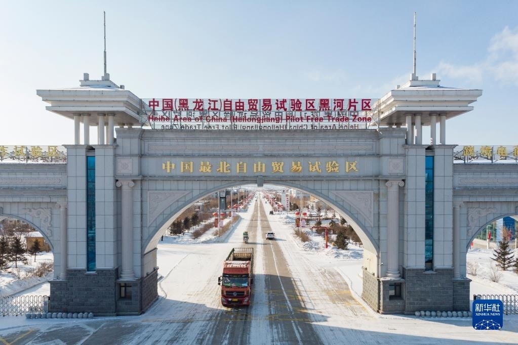 2月11日，車輛駛出中國(guó)（黑龍江）自由貿(mào)易試驗(yàn)區(qū)黑河片區(qū)大門(mén)（無(wú)人機(jī)照片）。新華社記者 謝劍飛 攝