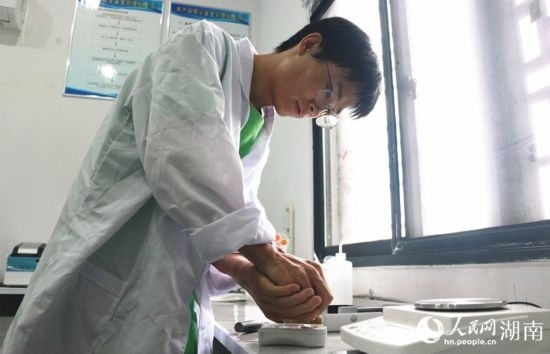 吳健筆在獼猴桃科技小院實驗室測量水果糖分。 人民網(wǎng)記者 劉賓攝