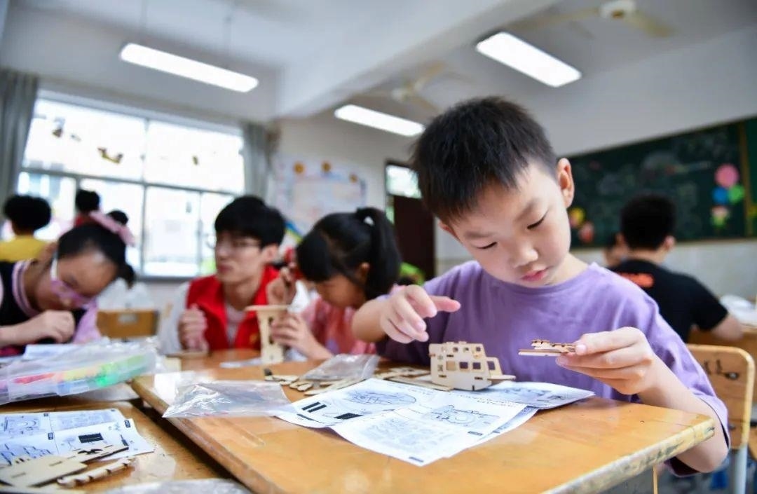 △今年7月，在浙江余姚市舜北小學(xué)暑托班內(nèi)，孩子們制作太陽能科學(xué)實驗裝置。