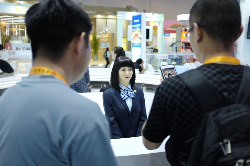 9月1日，媒體記者在國(guó)家會(huì)議中心與服務(wù)機(jī)器人互動(dòng)。新華社記者 劉夢(mèng)琪 攝