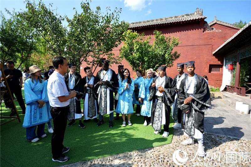 圖為選手們聽(tīng)導(dǎo)游講解。人民網(wǎng) 盧鵬宇攝