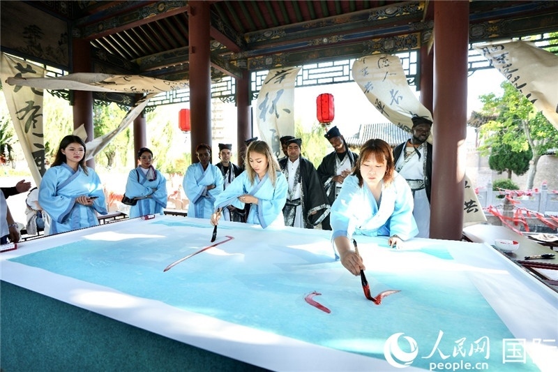 選手們提筆書(shū)寫(xiě)“家園”二字。人民網(wǎng) 盧鵬宇攝