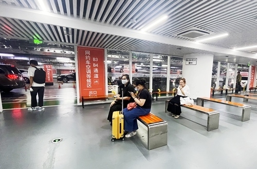 旅客在網(wǎng)約車空調(diào)等候區(qū)等候網(wǎng)約車。人民網(wǎng)記者 喬雪峰攝