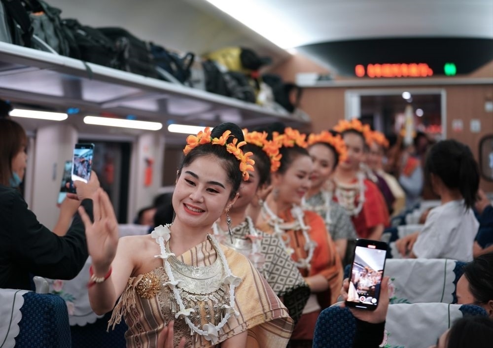 2023年4月13日，老撾工作人員在中老鐵路上開行的D887次國際旅客列車上表演。新華社記者 邢廣利 攝
