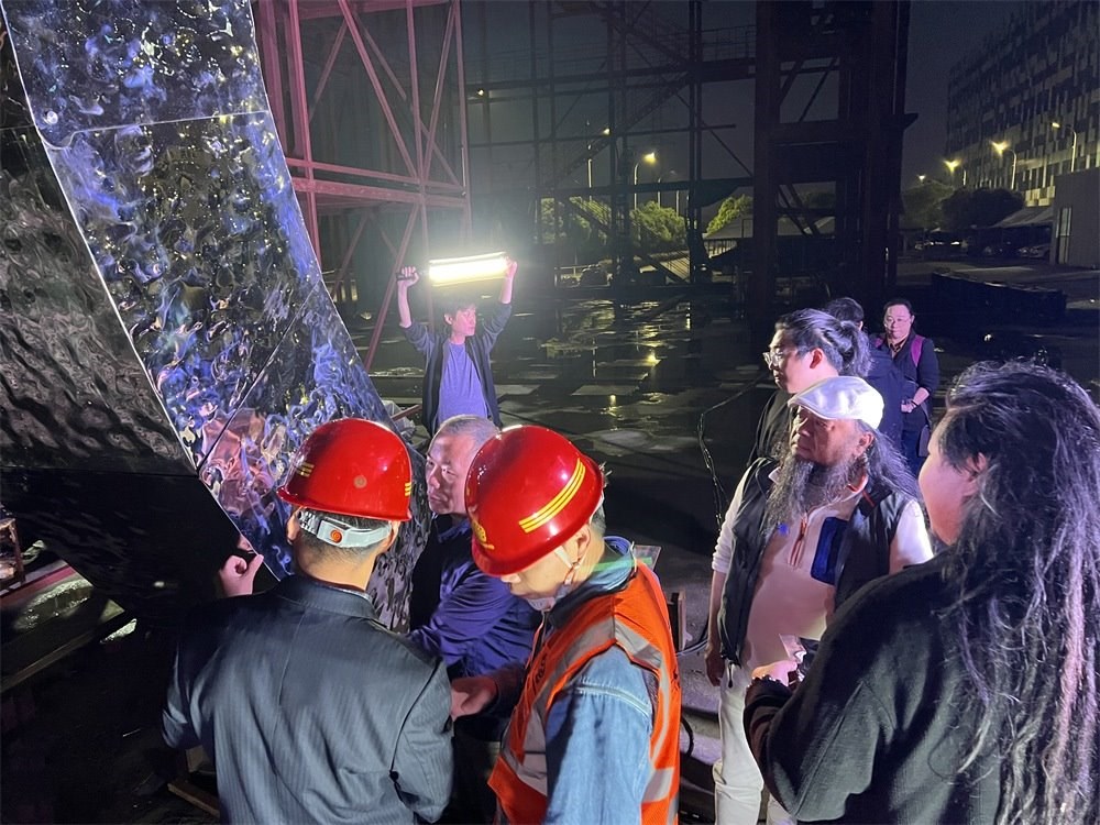 林崗（右二）和團隊查看主火炬制作進度。受訪者供圖