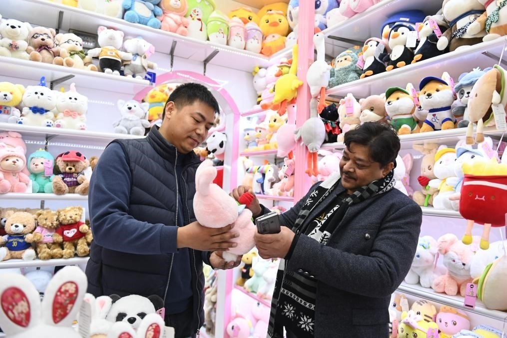 2023年2月2日，來自印度的客商（右）在義烏國際商貿(mào)城的一家玩具店鋪內(nèi)選購商品。新華社記者 黃宗治 攝