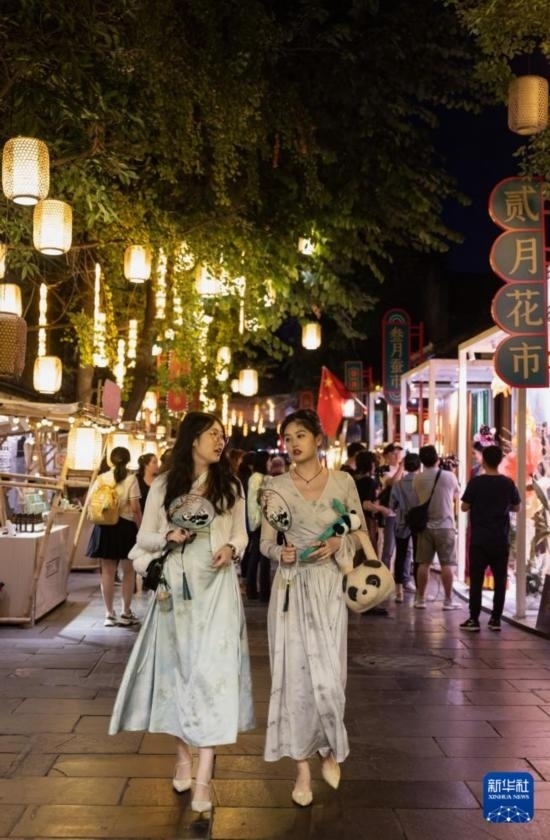 在成都寬窄巷子，兩位來(lái)自安徽的游客在新“十二月市”街區(qū)游覽（9月29日攝）。