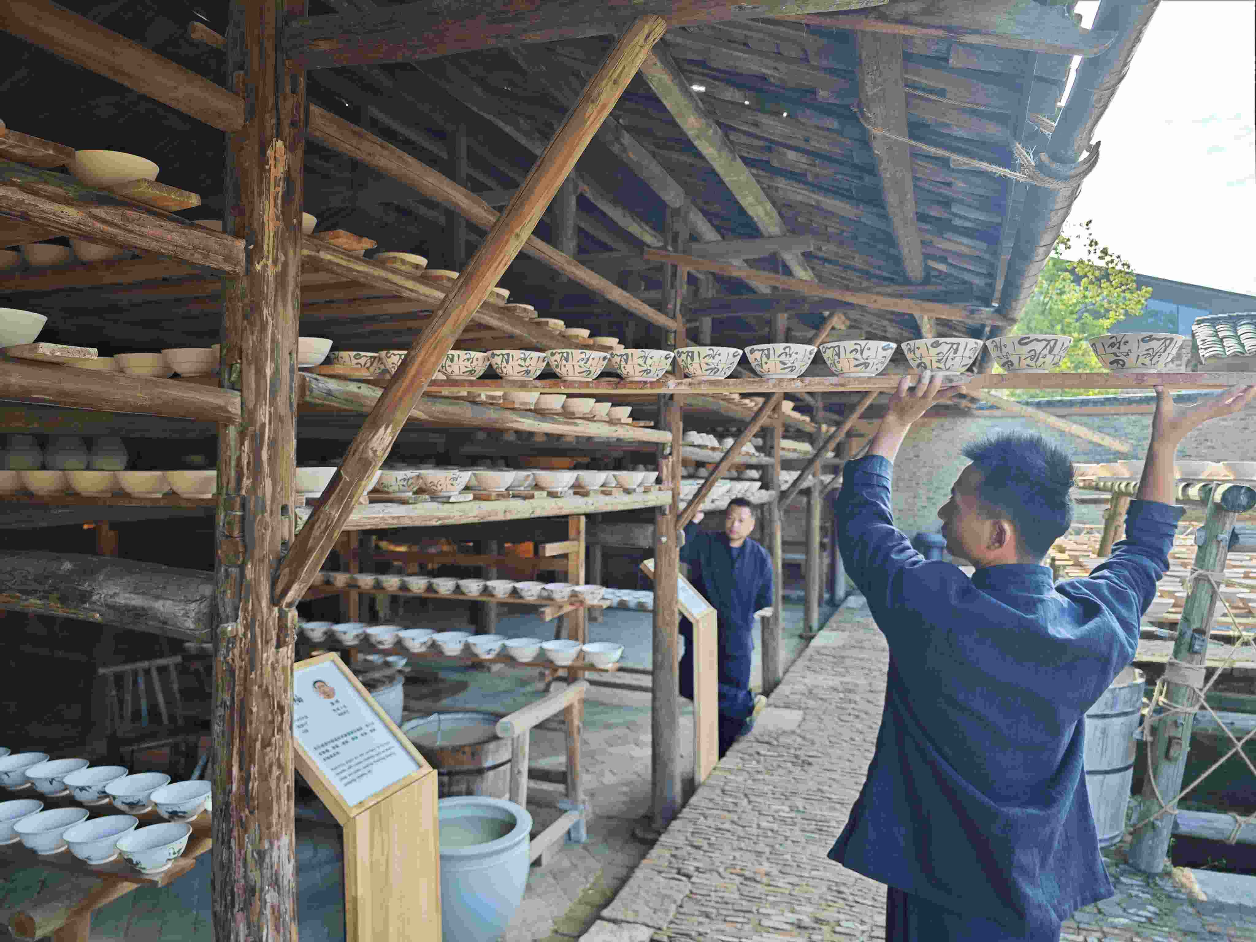 △陶陽(yáng)里歷史文化街區(qū)里，工匠將陶瓷工藝品放到架上晾干。（總臺(tái)央視記者彭漢明拍攝）
