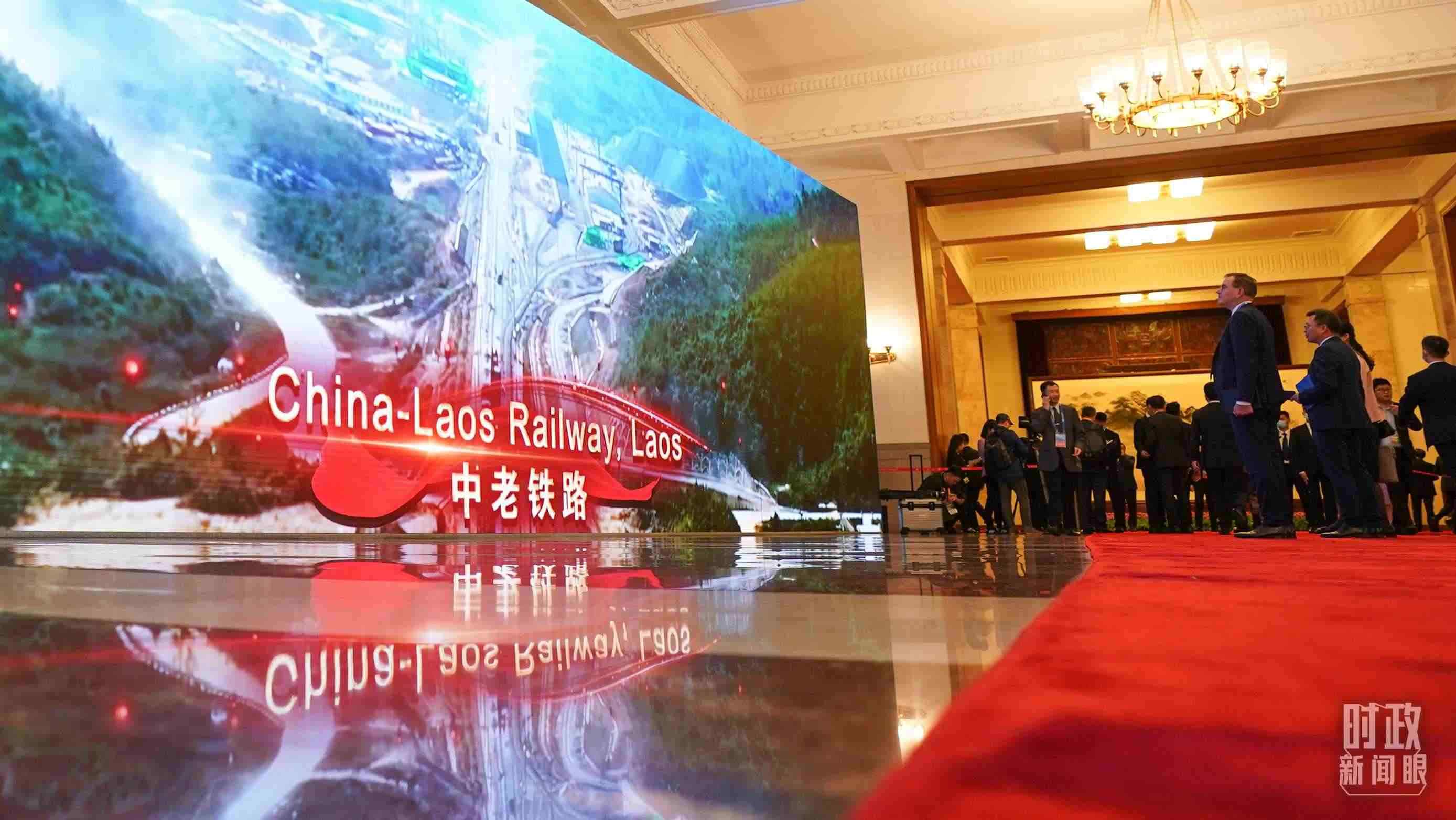 △人民大會堂，參會人員駐足了解“一帶一路”標(biāo)志性項目。（總臺國廣記者李晉拍攝）