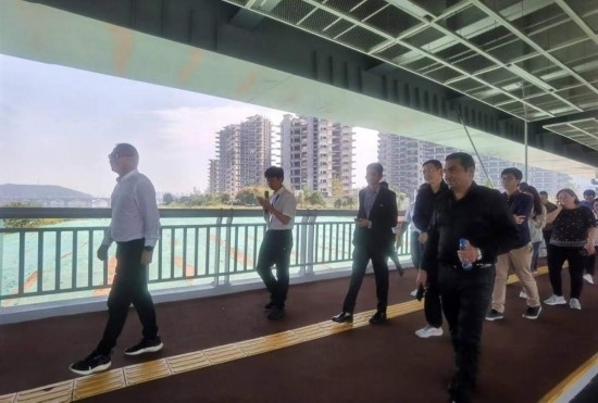 10月24日，2023“一帶一路”媒體合作論壇聯(lián)合采訪團團員走在清水塘大橋景觀通道上。本報記者 常雯宜攝