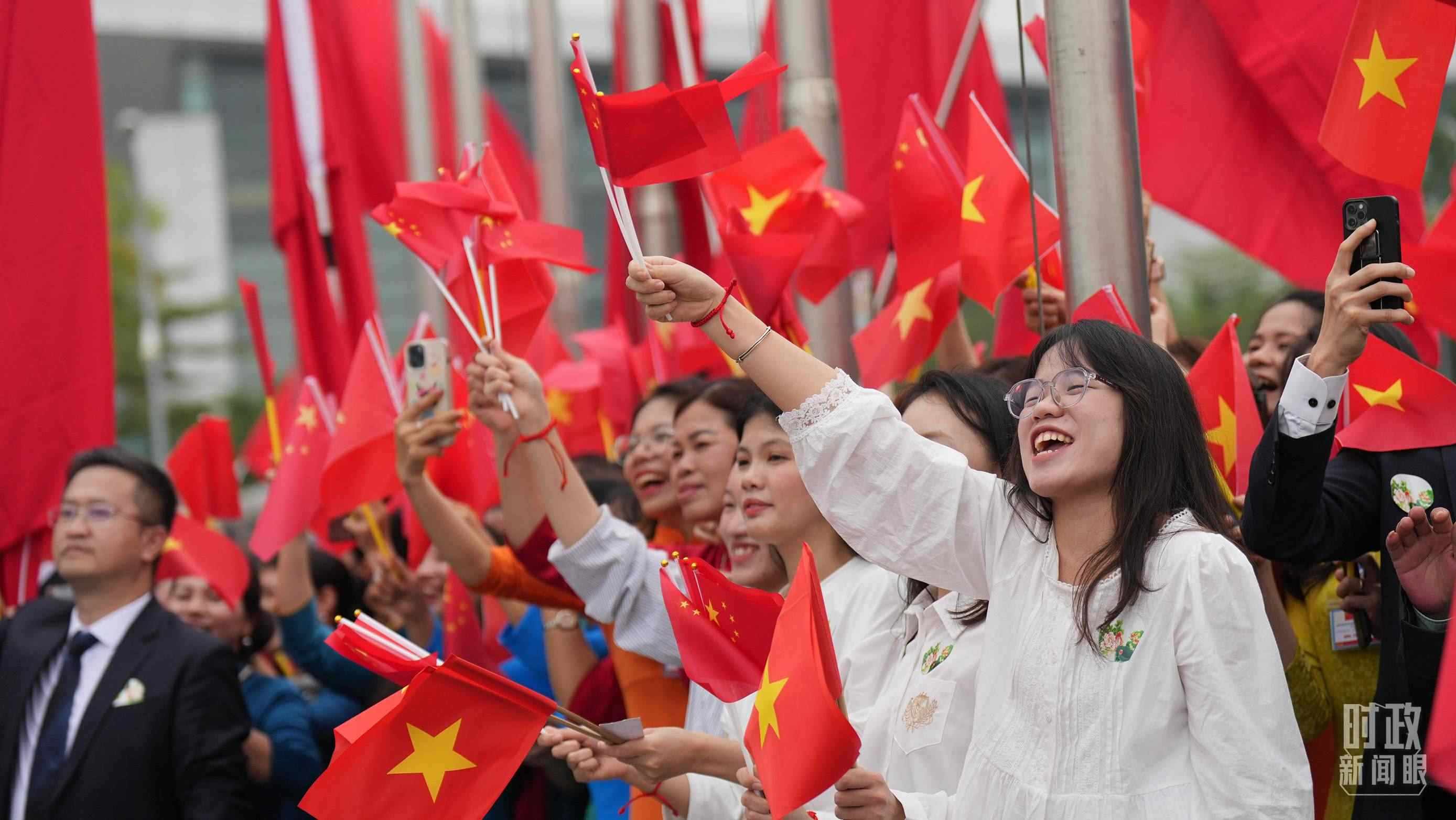 △人們揮舞兩國旗幟歡迎習(xí)近平訪越。（總臺國廣記者李晉拍攝）