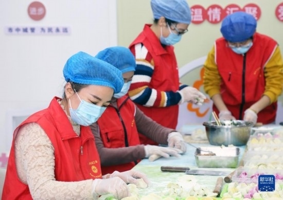12月16日，在山東省棗莊市市中區(qū)城管藍(lán)職工志愿服務(wù)驛站，愛心志愿者為戶外勞動(dòng)者包水餃。