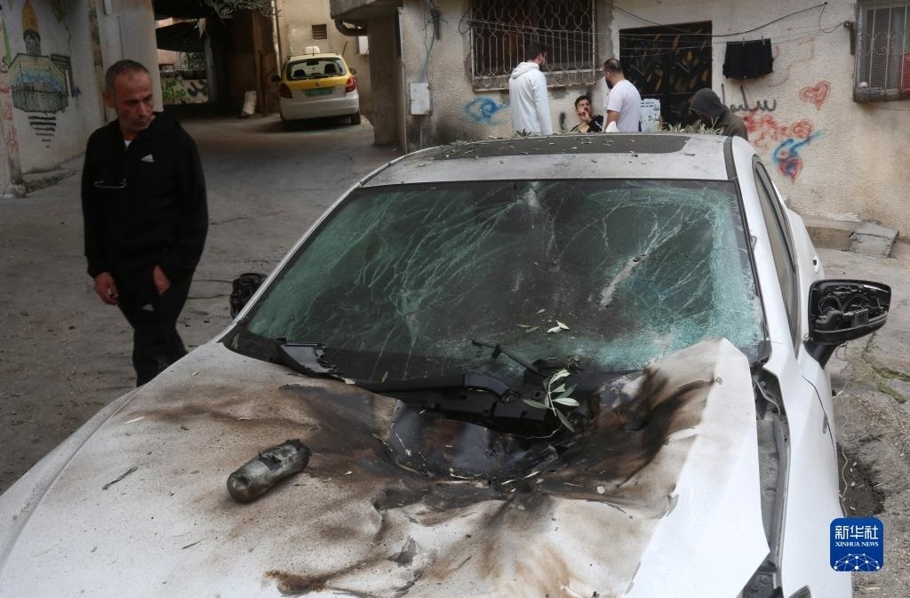 12月17日，在約旦河西岸城市圖勒凱爾姆附近的一處難民營(yíng)，人們查看在沖突中損毀的車(chē)輛。新華社發(fā)（尼達(dá)爾·艾仕塔耶?dāng)z）
