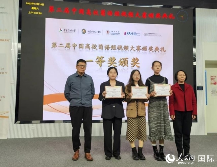 澳門大學(xué)中葡雙語教學(xué)暨培訓(xùn)中心主任姚京明（左一）和中國傳媒大學(xué)外國語言文化學(xué)院院長文春英（右一）為一等獎獲得者頒獎。人民網(wǎng)記者 魯揚攝