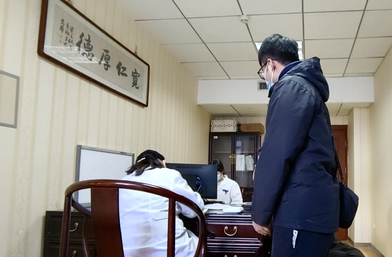 陪診師大飛陪同來(lái)京就診的患者在醫(yī)院?jiǎn)栐\。人民網(wǎng)記者 任妍攝