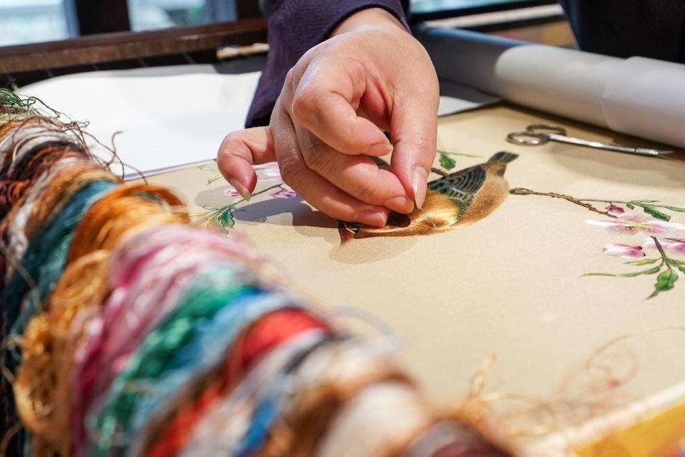 △2023年7月6日，盧建英在江蘇蘇州平江路的工作室內(nèi)刺繡。