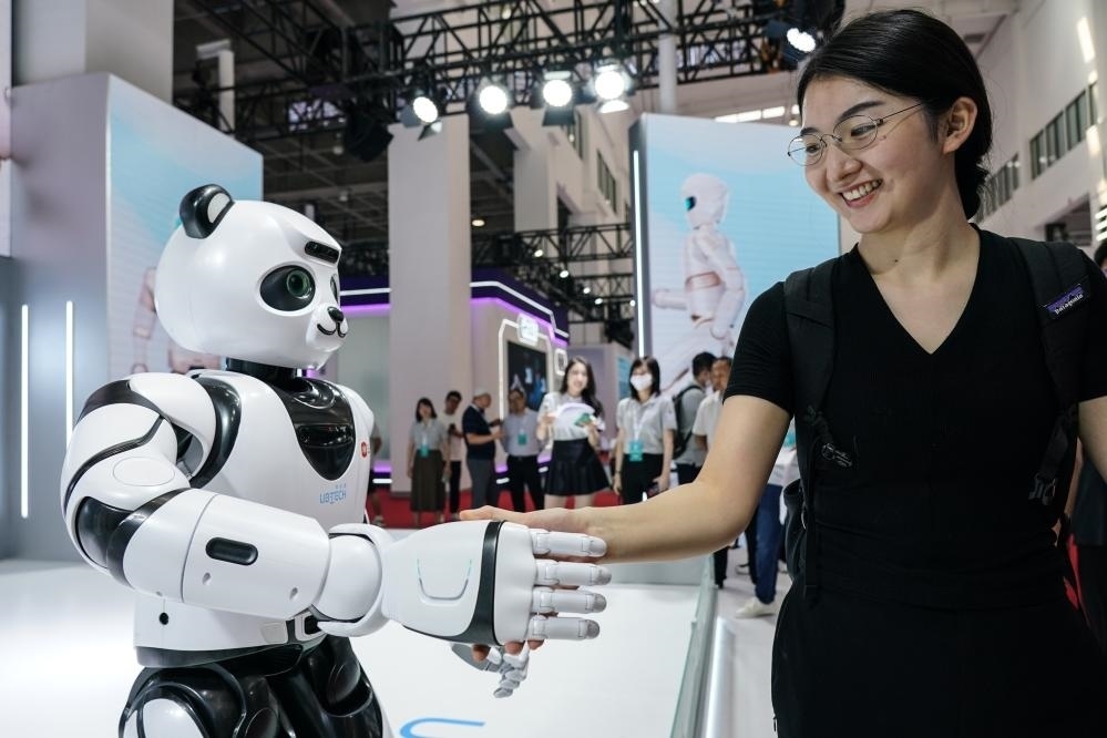 2023年8月16日，一名女士在北京舉辦的2023世界機器人大會現場與智能機器人握手。新華社記者彭子洋攝