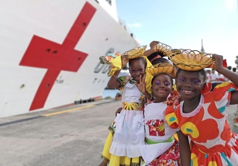 2018年10月，在安提瓜和巴布達首都圣約翰，當?shù)匦∨笥焉泶﹤鹘y(tǒng)服裝歡迎中國海軍“和平方舟”醫(yī)院船首次到訪。