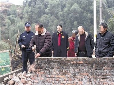  圖③：庭審結(jié)束后，在法官的見證下，陳某在院壩邊重新開鑿一條通道。