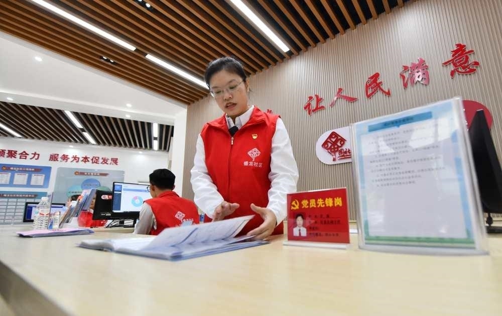 △2023年12月14日，廣西南寧市蟠龍社區(qū)，工作人員在為居民服務(wù)。