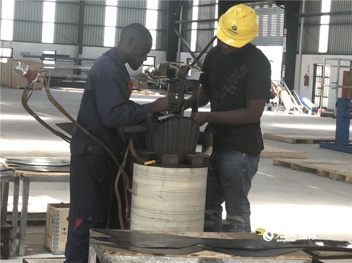 經(jīng)貿(mào)合作區(qū)廠房內(nèi)，當(dāng)?shù)毓と苏诰o張作業(yè)。人民網(wǎng)記者 黃培昭攝