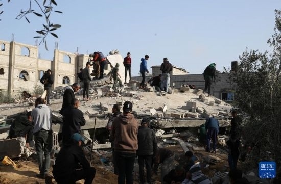  3月3日，在加沙地帶南部城市拉法，人們查看被以軍空襲破壞的建筑。新華社發(fā)（哈立德·奧馬爾攝）