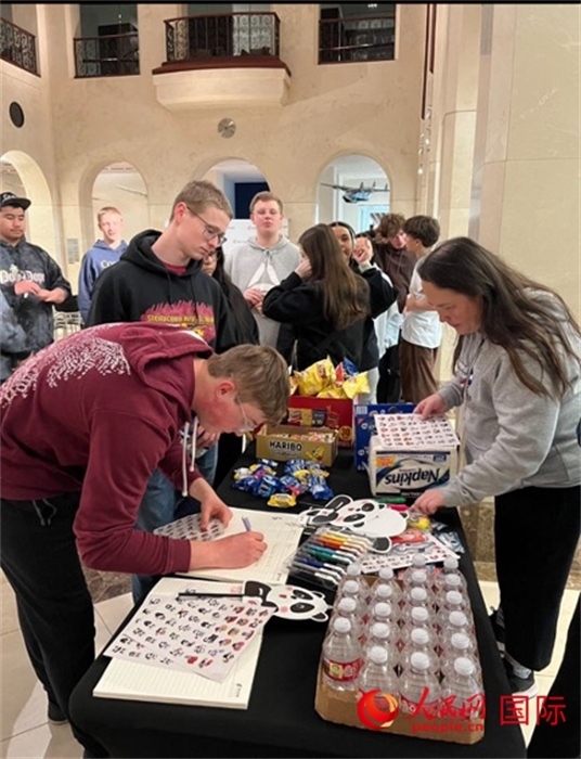 學(xué)生們出發(fā)前紛紛在留言簿留言。人民網(wǎng)記者 鄧圩攝