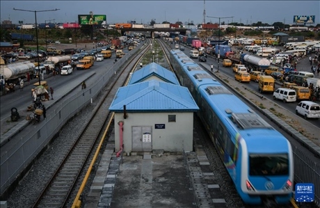 3月4日，在尼日利亞拉各斯，一列輕軌藍線列車行駛至公路交通擁堵路段附近。新華社記者 韓旭 攝
