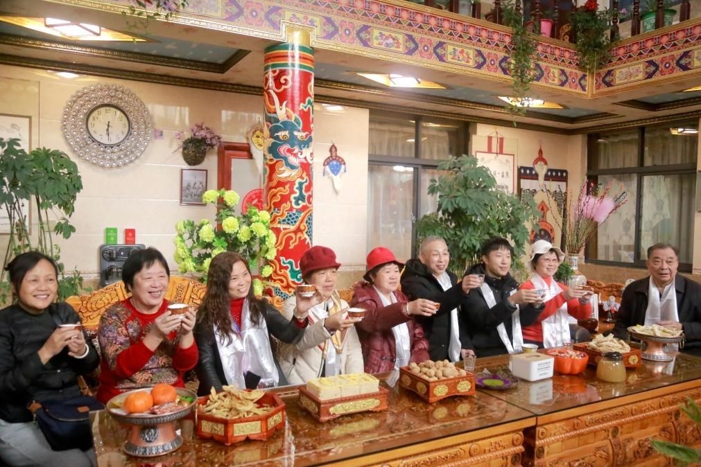 游客們?nèi)胱∶袼藓?，舉杯共飲酥油茶。新華社記者 邱星翔 攝